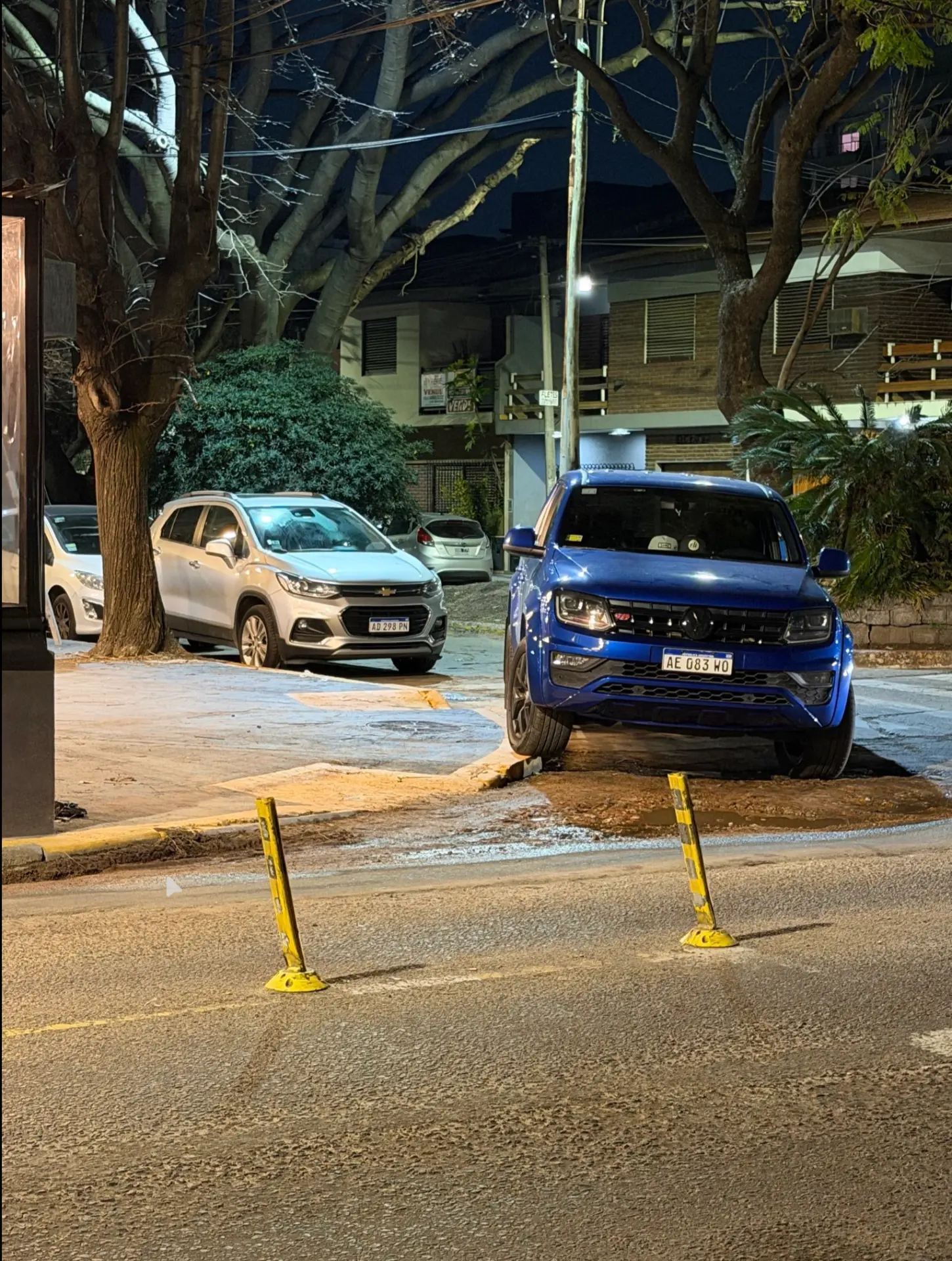 VW Amarok azul estacionada sobre la vereda y sobre la ochava de la esquina.