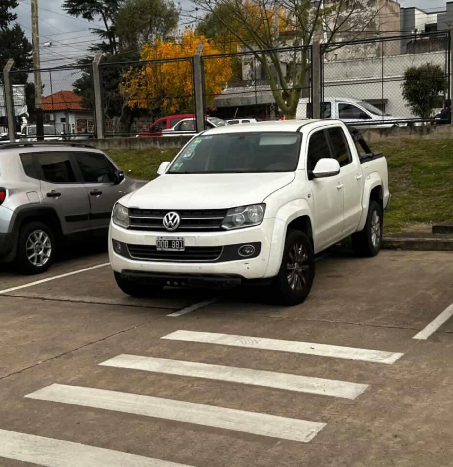 VW Amarok blanca ocupando 2 lugares de estacionamiento.